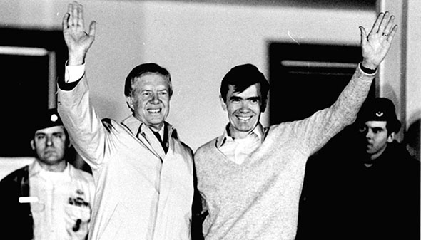 Former President Jimmy Carter waves as he looks at former hostage Bruce Laingen, from Bethesda, MD, former Charge d'Affaire at the U.S. Embassy in Tehran, on the balcony of the U.S. Air Force hospital, January 22, 1981 in Wiesbaden, Germany.  Carter paid a three hour visit to the hostages from Iran at the hospital, where they are lodged after 444 days of captivity. (AP Photo)
